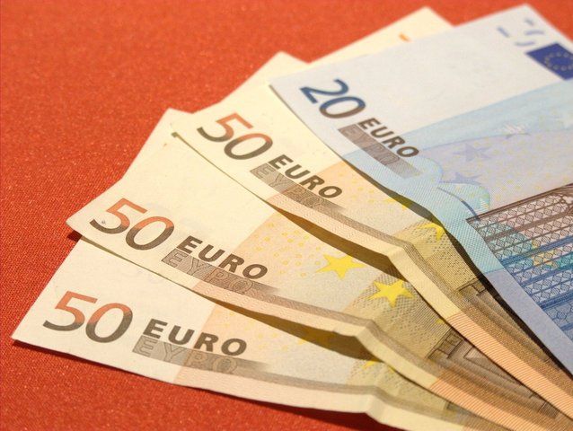 čtyři euro bankovky na červeném pozadí.jpg